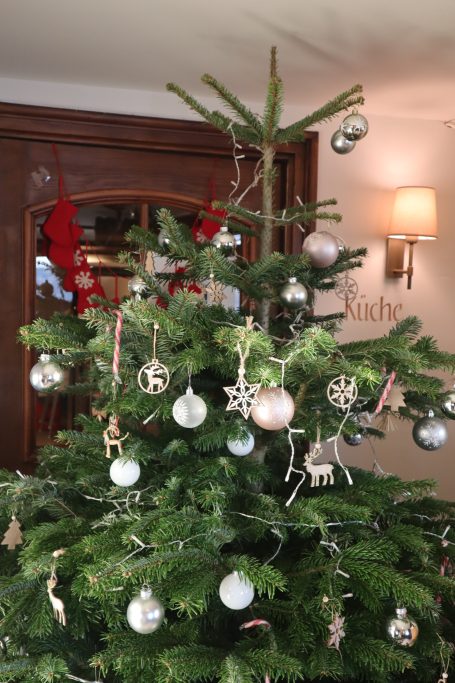 Ein festlich geschmückter Weihnachtsbaum steht im Eingangsbereich des Restaurants